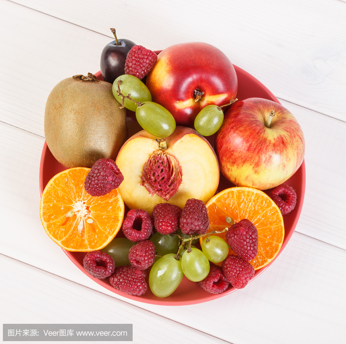 新鲜成熟的水果放在盘子里,放在白板上